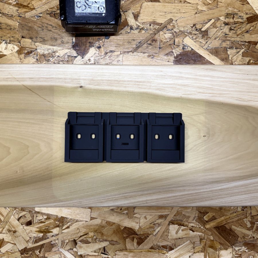 3D-printed triple battery holder mounted on a poplar wall organizer board